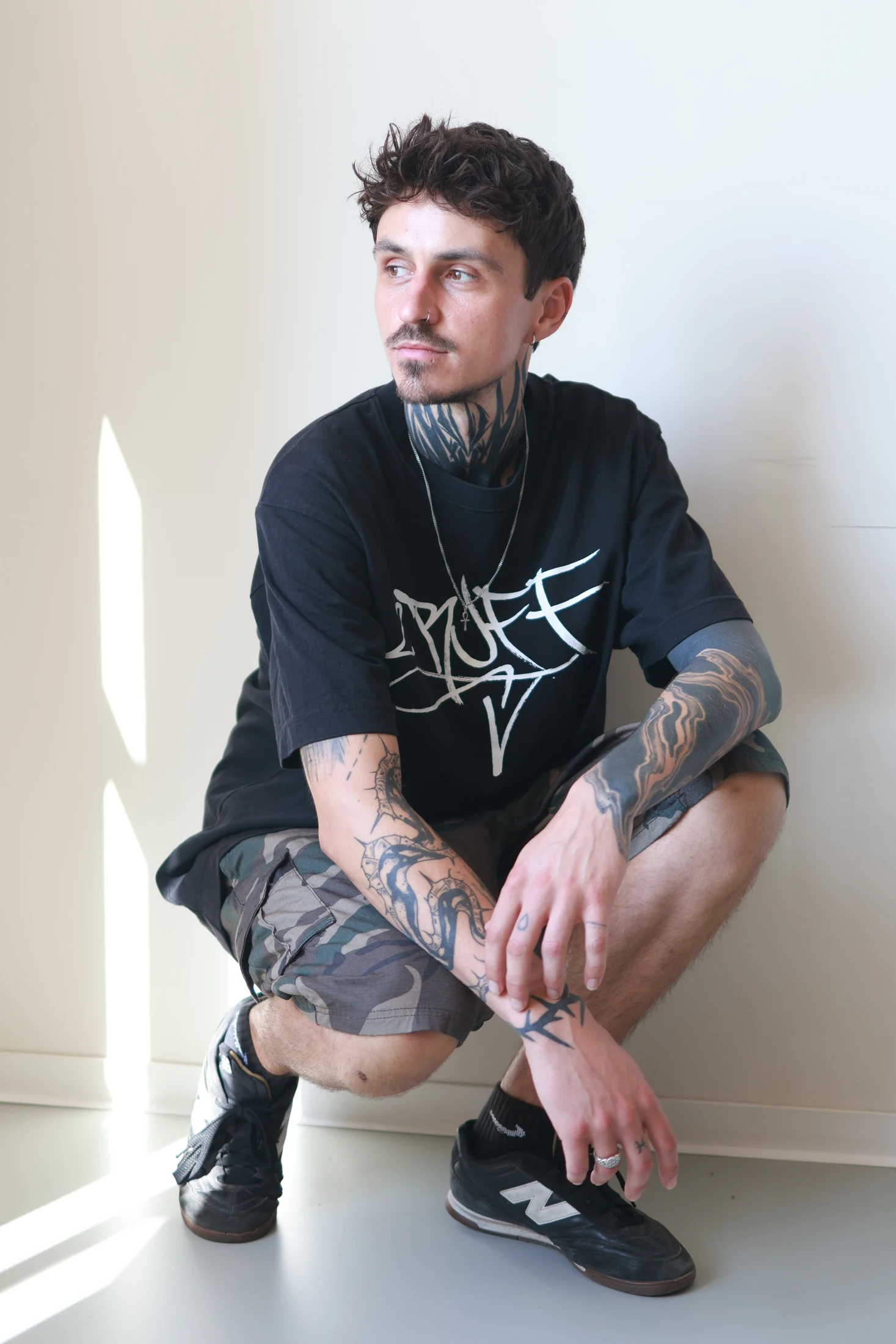 Chris im dunklen Outfit in einer sitzenden Aufnahme