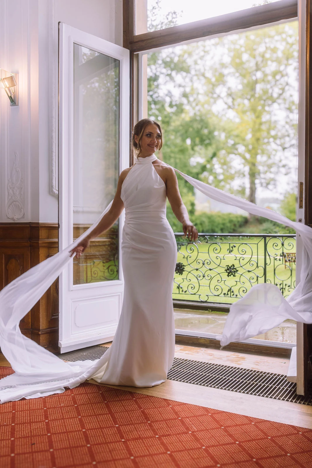 Natalie im Brautkleid am geöffneten Fenster